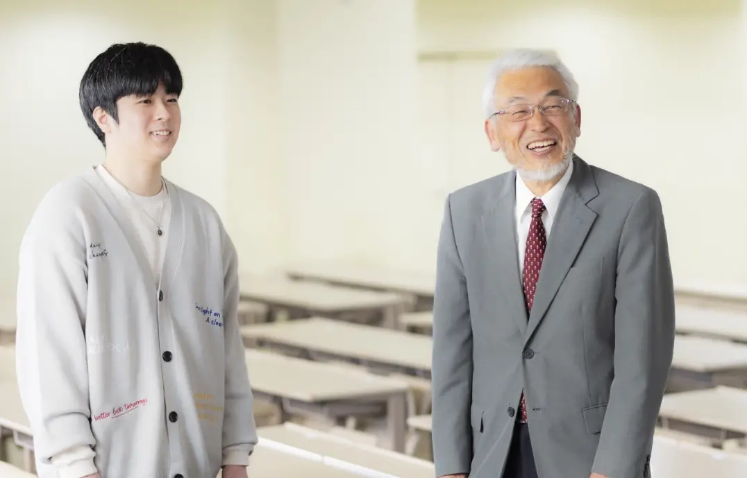 加納教授と学生の横谷さんが立って話している様子